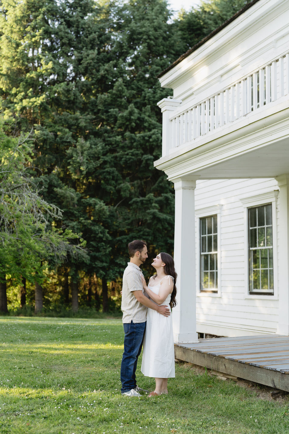 Couple poses in front of historical building porch.