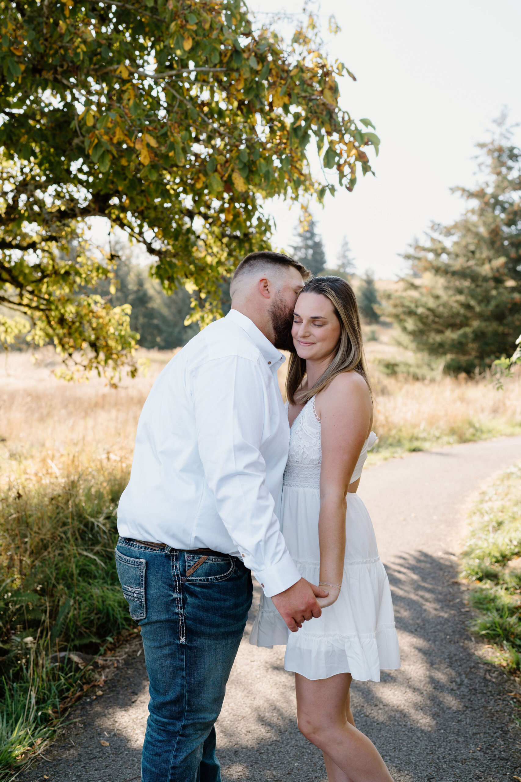 Man kisses woman on the cheek during Portland engagement session.