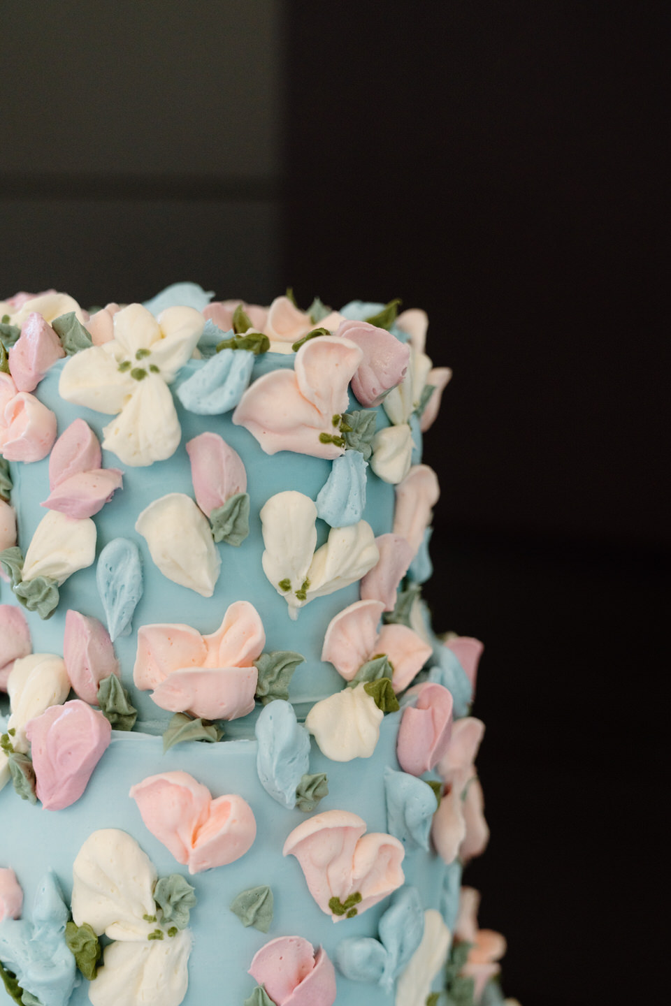 Close-up of the vibrant cake from Sugar Mama Kitchens with pink, peach, and coral floral accents.