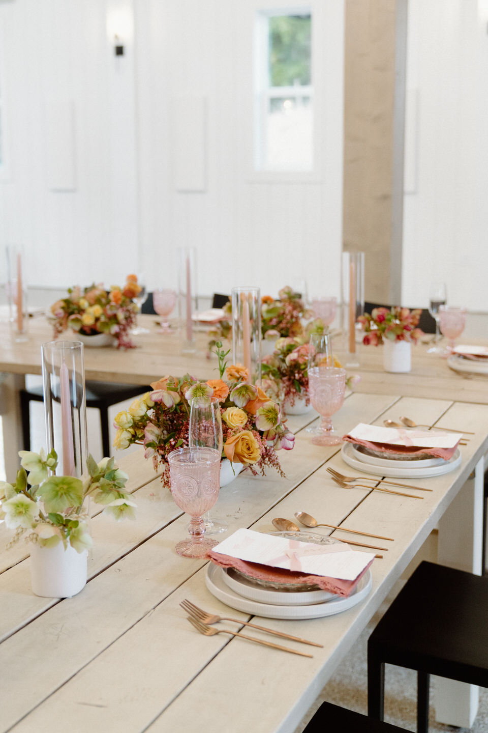 A romantic tablescape filled with soft pink blooms, lush textures, and custom stationery by Life in Letters.