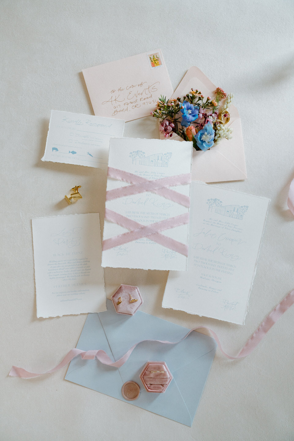 A modern-meets-organic flat lay of the stationery suite, with handwritten details and floral flourishes.