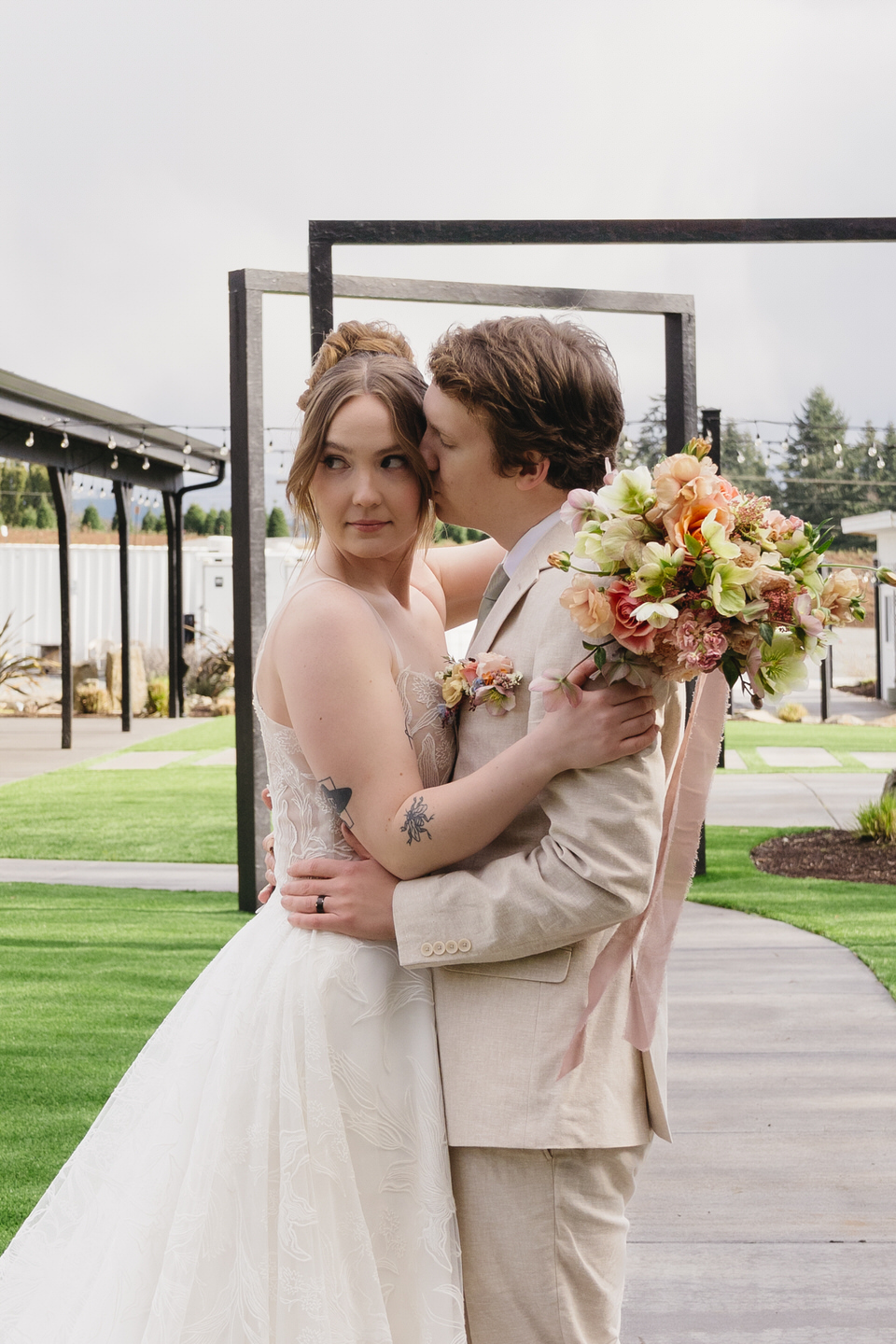 A bouquet with peach tones pops as the couple strolls through the archways at Sage & Social.