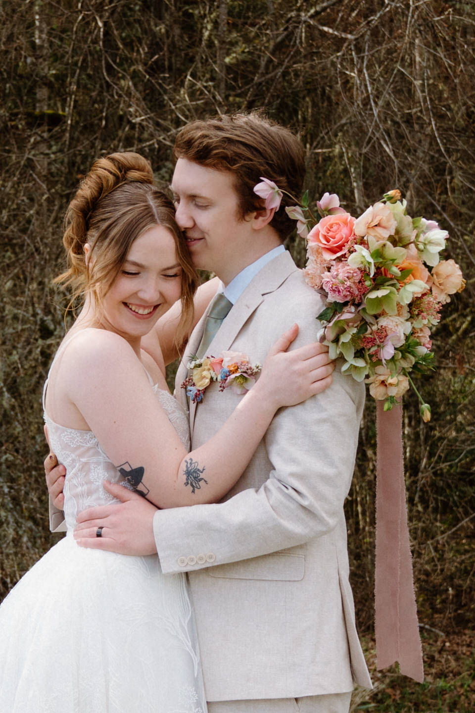 A pastel peach bouquet with spring florals is held delicately as the bride walks through the venue grounds.