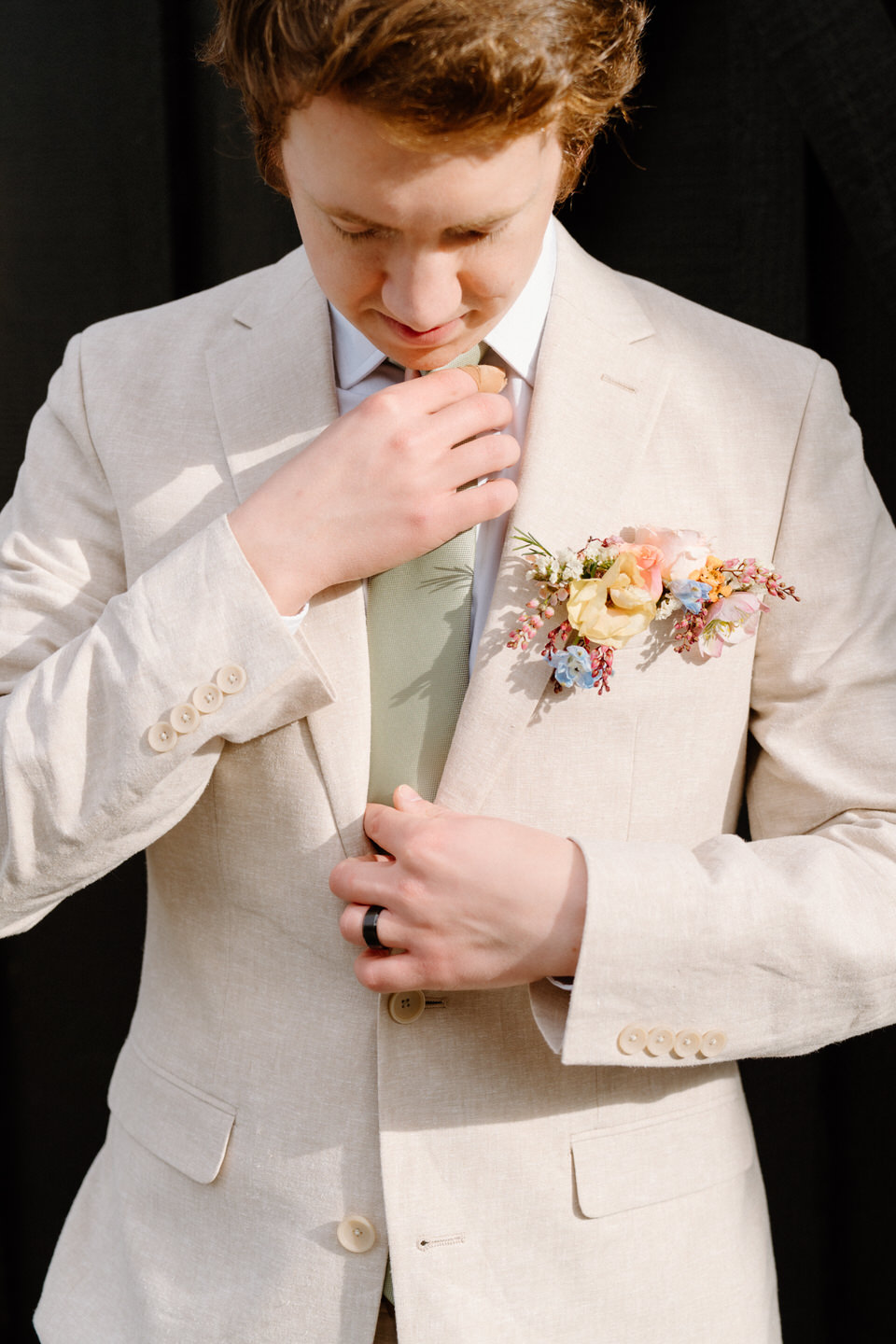 The groom's modern pocket boutonniere adds a fresh, clean look to a neutral-toned wedding suit.