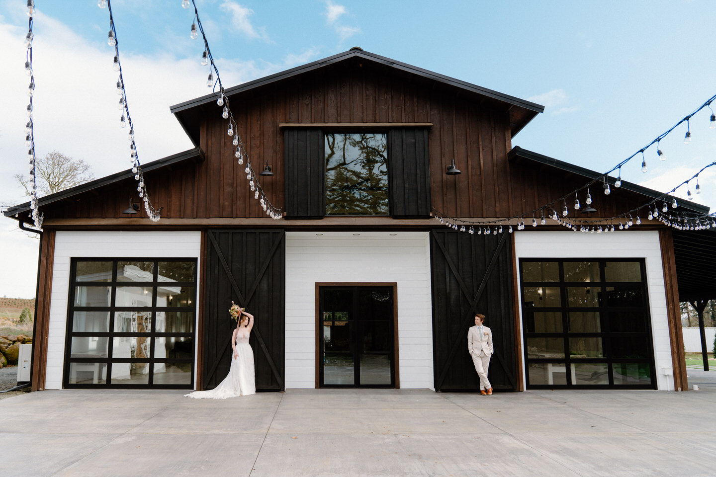 A sweeping wide shot of Sage & Social’s dark wood barn doors contrasted against the bright, open sky.