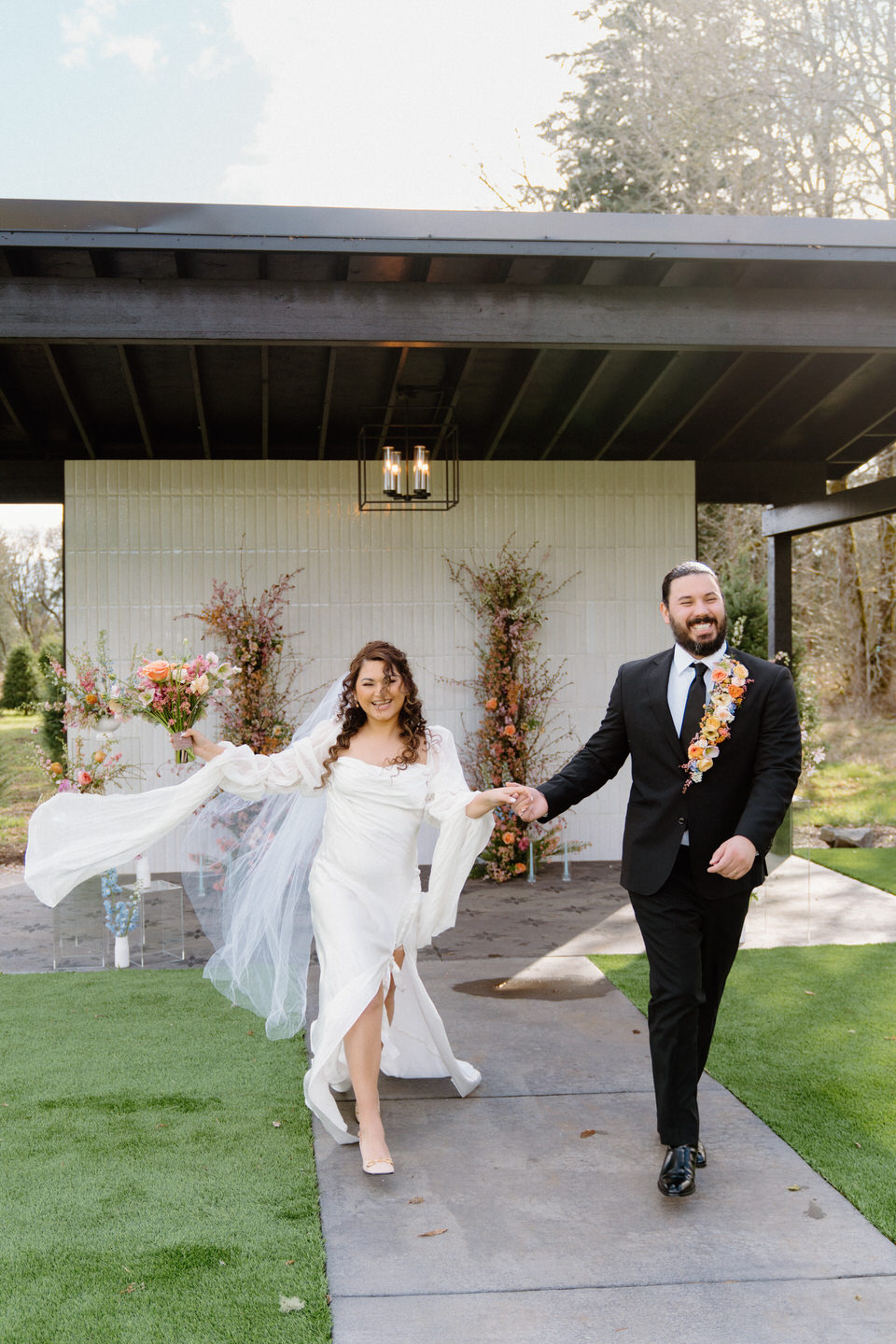 Couple celebrates cheerfully as they walk back down the aisle from their Sage & Social wedding ceremony.