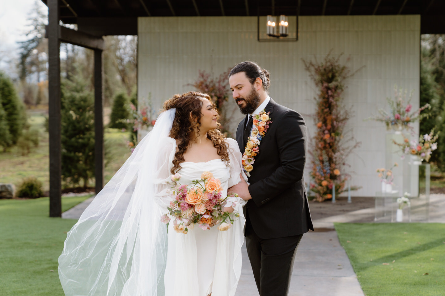 A couple embraces under glowing spring light at Sage & Social, surrounded by lush florals and modern design.