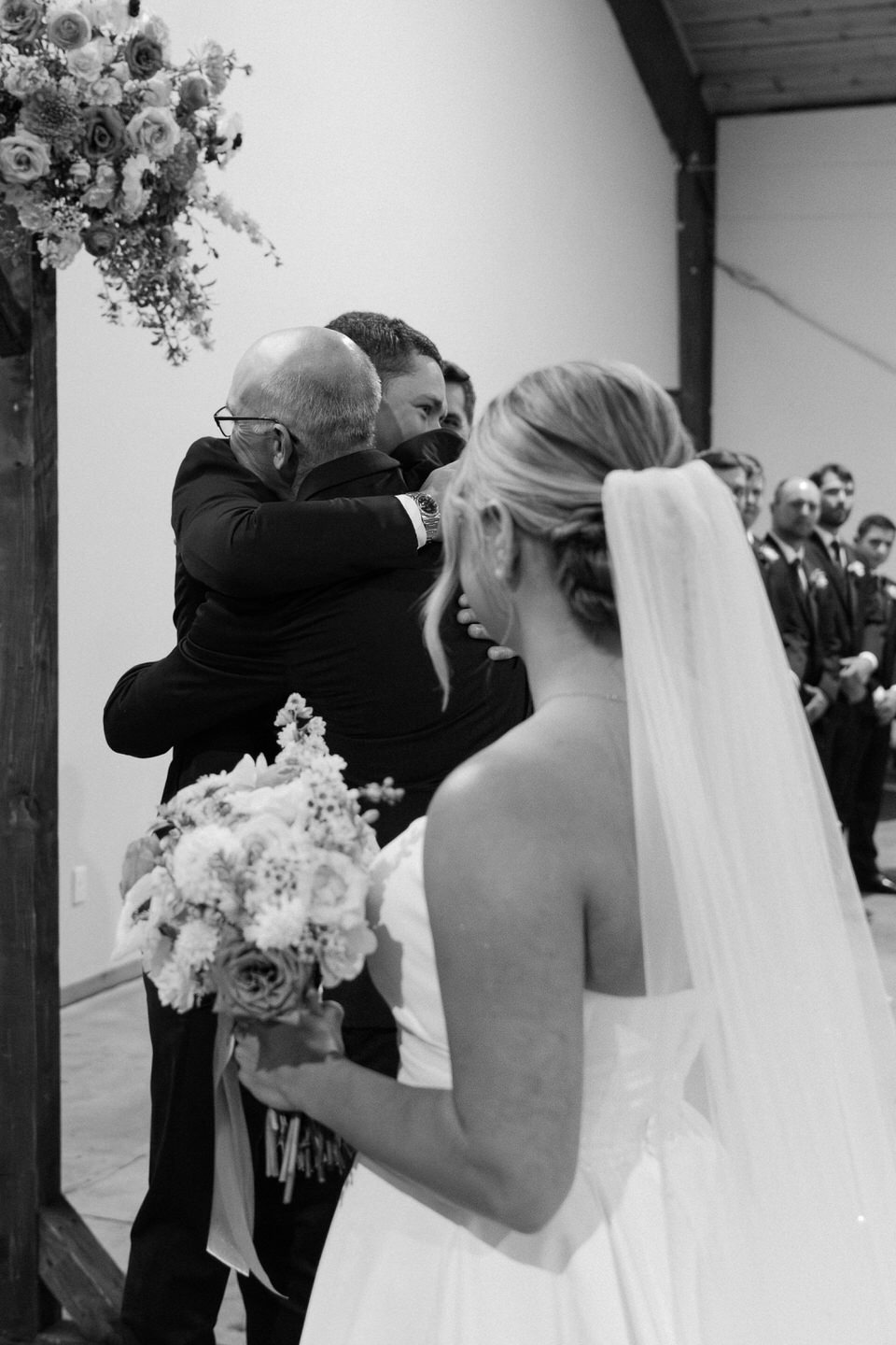 Black and white photo of father giving his daughter away during the wedding ceremony.