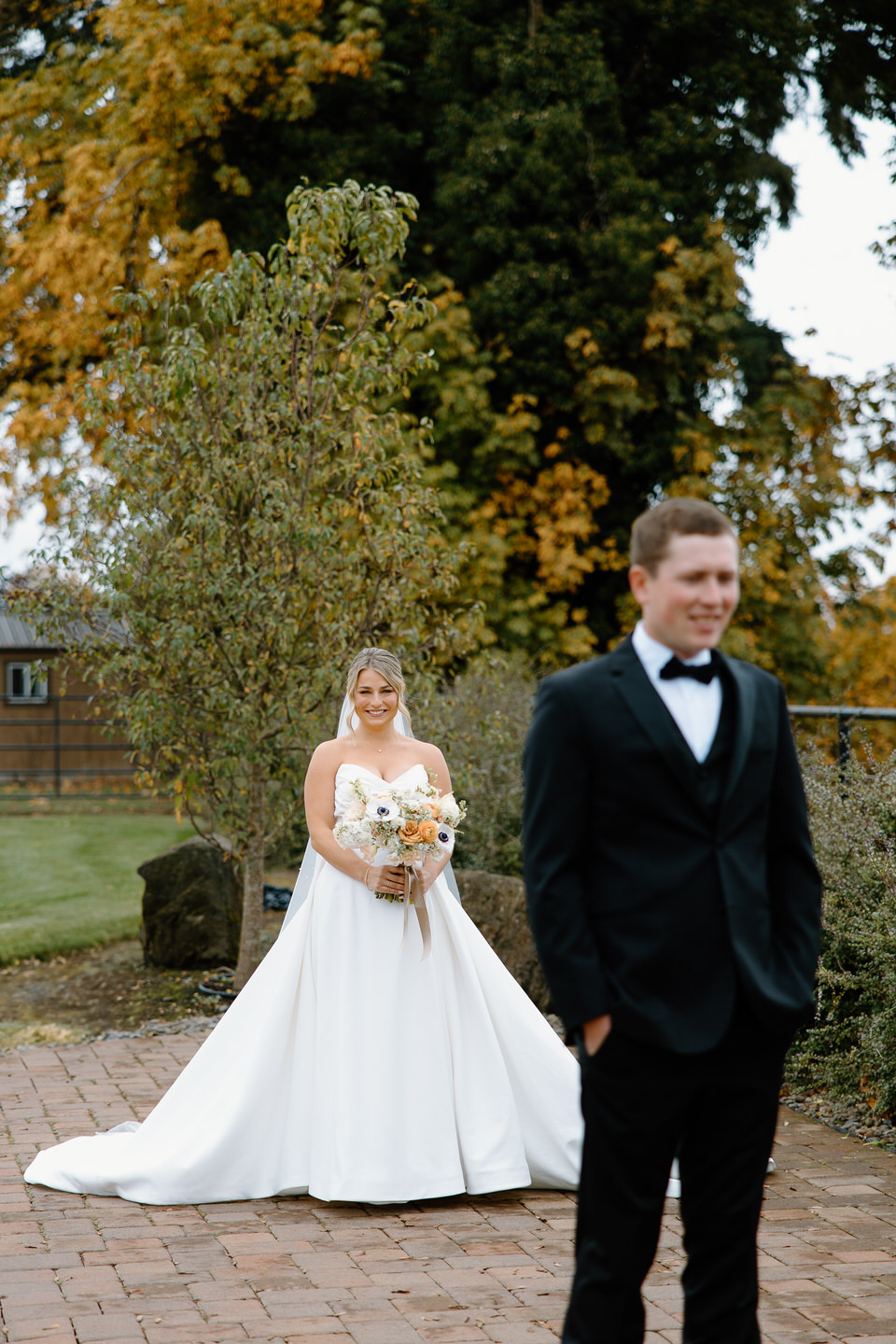 The groom, in his sleek black suit, waits to see his bride for the first time in her gown.