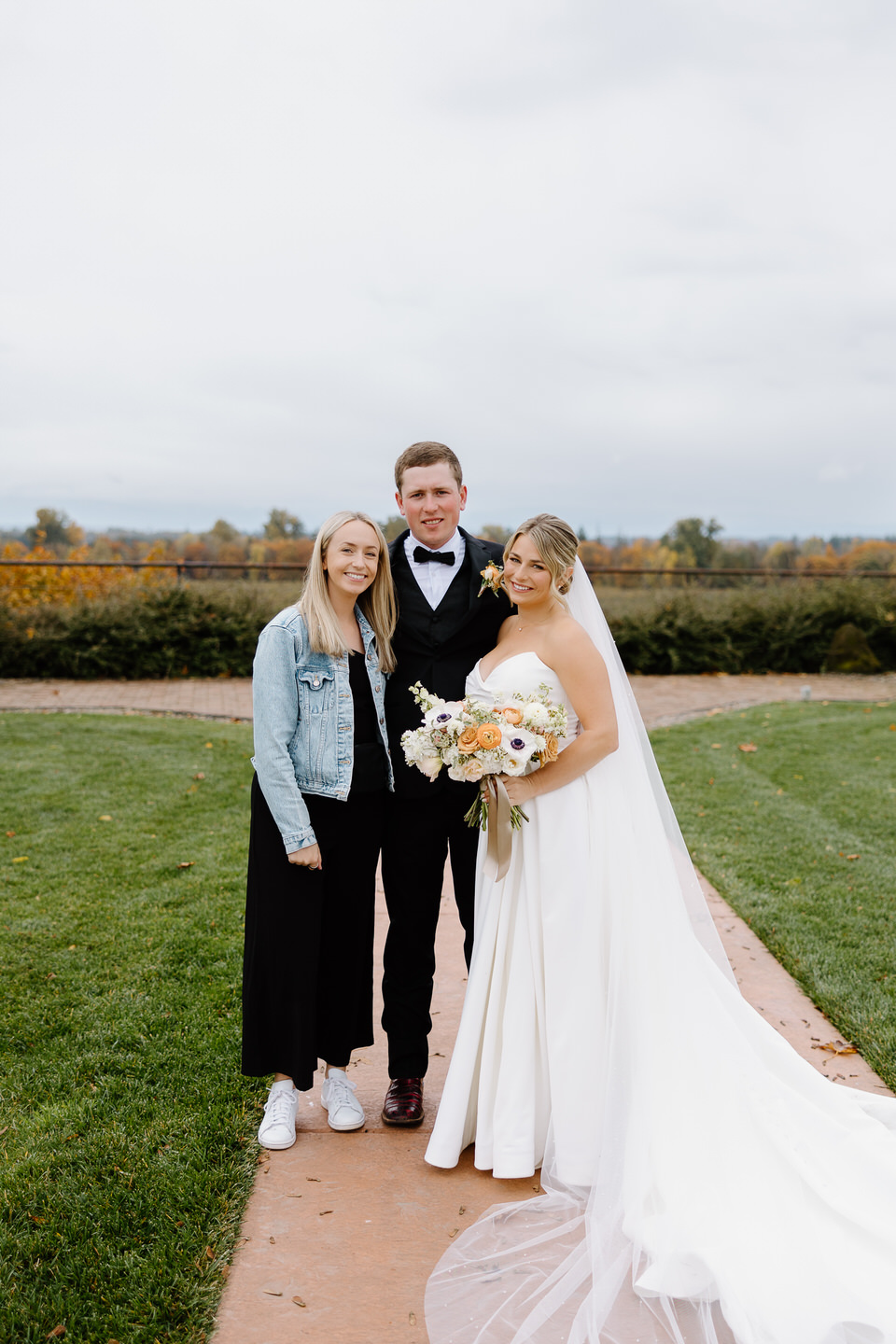 Kendi Photos smiles with the bride and groom at The Barn at Countryside.