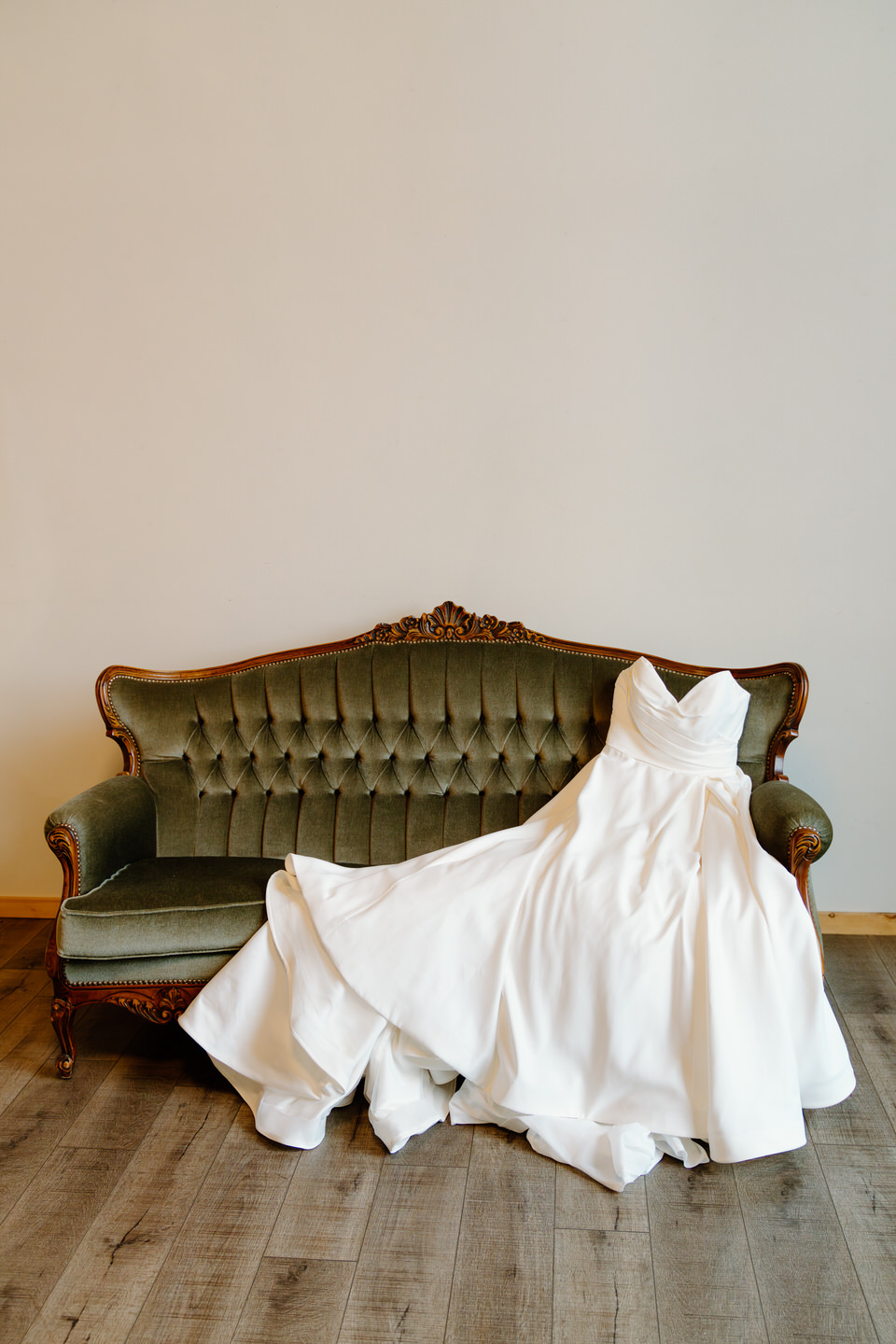 Ball gown wedding dress laid out on the couch at The Barn at Countryside.