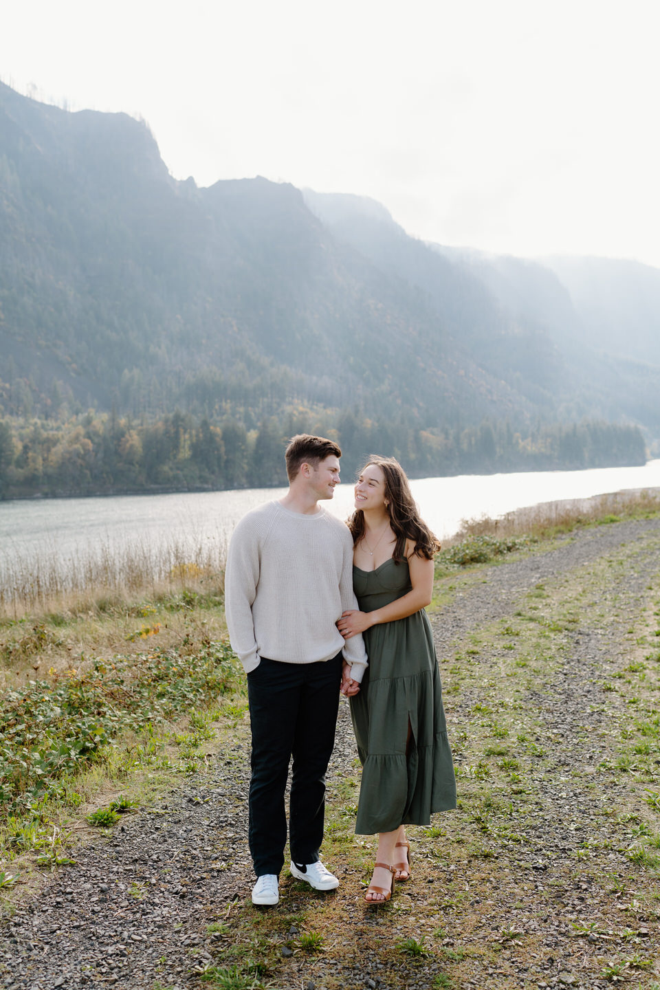 Couple posed in front of river and cliffs — classic fall engagement photos in the Columbia Gorge.