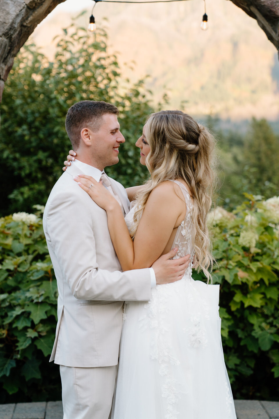 Bride and groom smile at each other with the Columbia River flowing behind them.