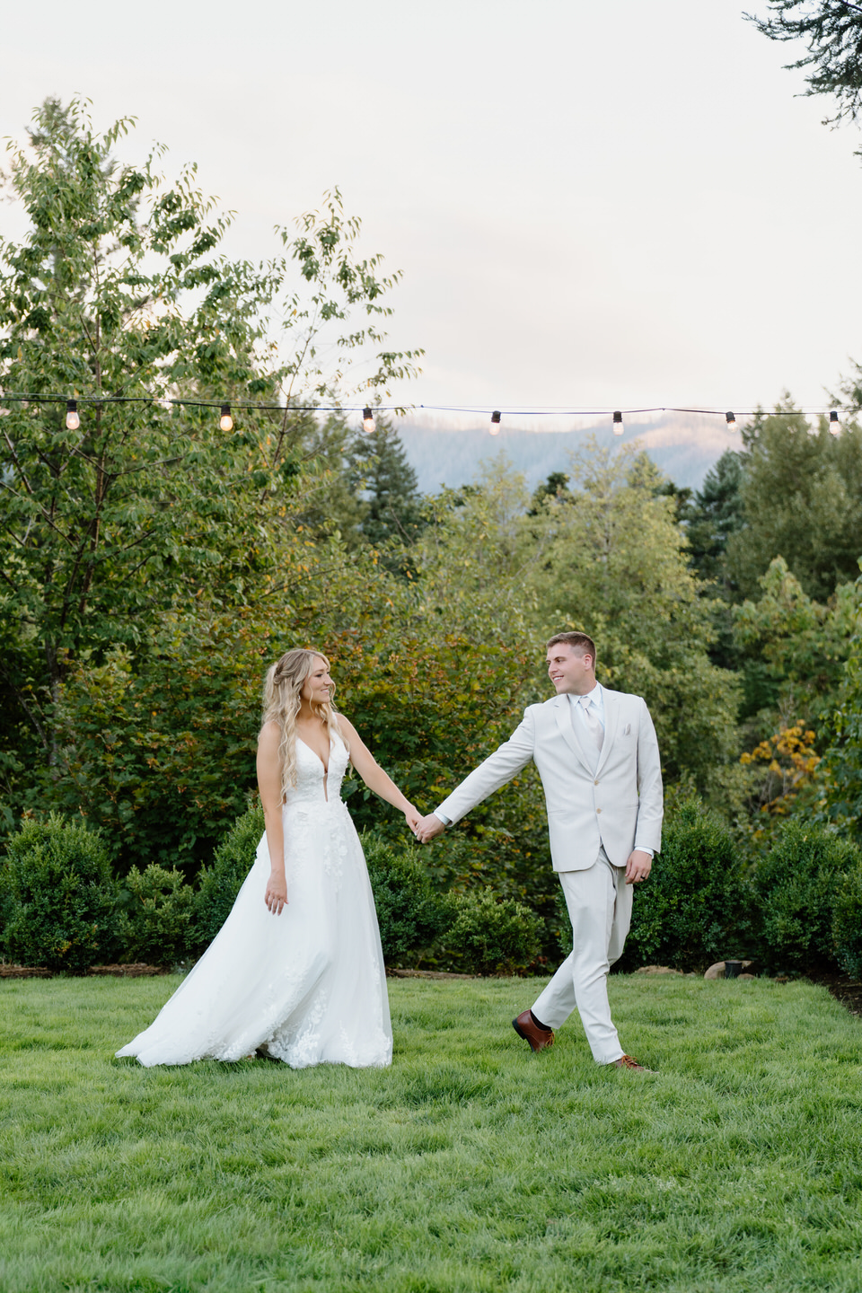 Groom leads his bride as they walk through the garden at Cape Horn Estate.