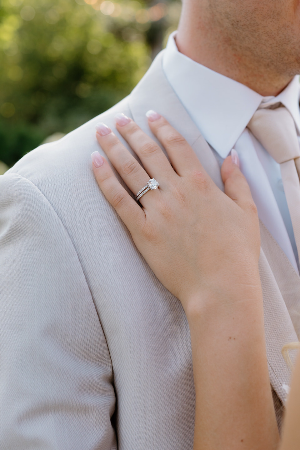Close up of bride's rings resting on the groom's chest.