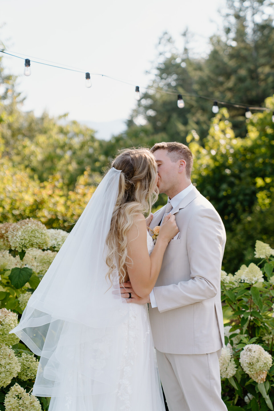 Bride grabs groom's suit jacket as they share a kiss.