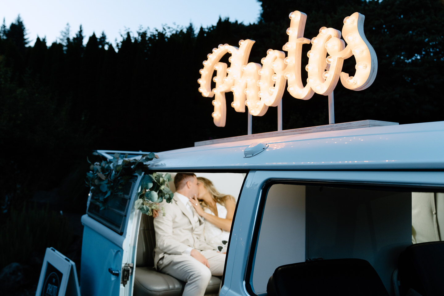 Bride and groom kissing inside the Photo Booth Bus.