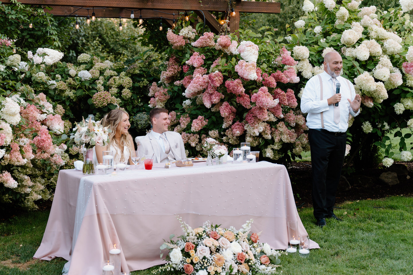 Bride and groom laugh during father of the bride's speech.