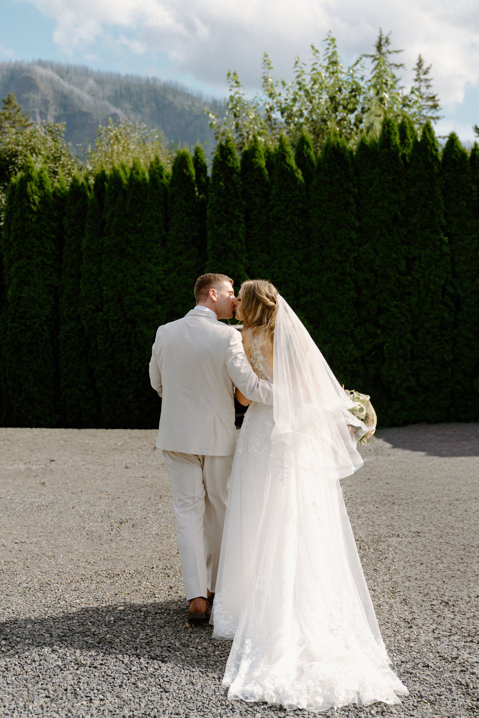 Couple kissing from behind as they exit the wedding ceremony.