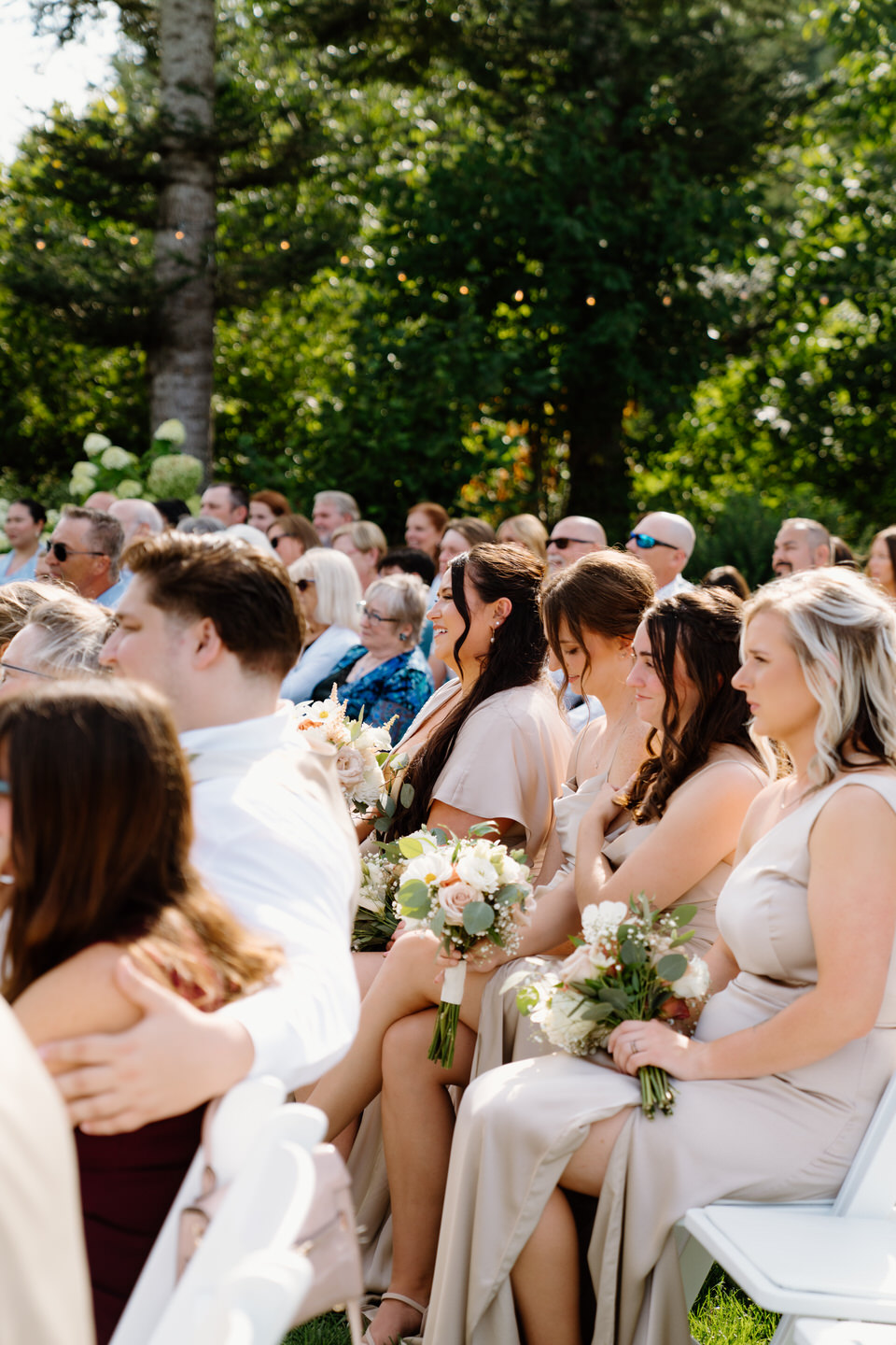 Bridesmaids seated and smiling during wedding ceremony at Cape Horn Estate.