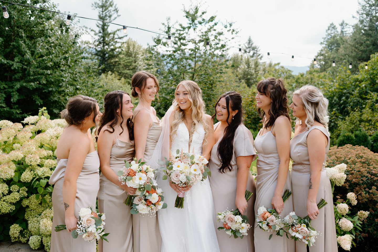 Bridal party portraits with the women looking at each other, holding pink and white bouquets.