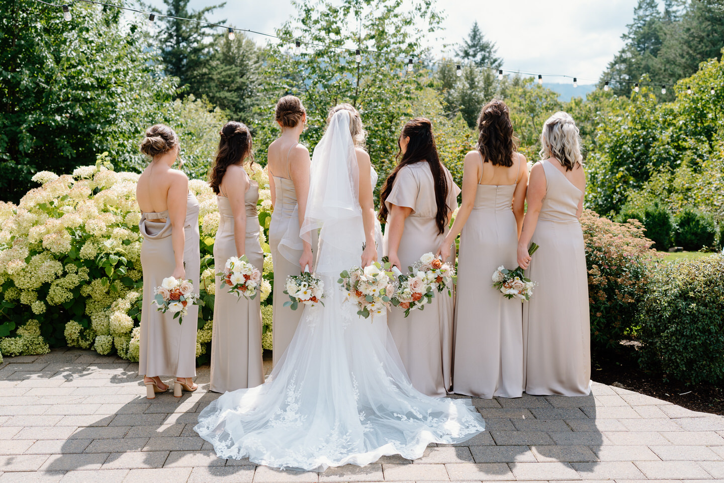 The back of the bridesmaids' dresses, holding bouquets behind them. 