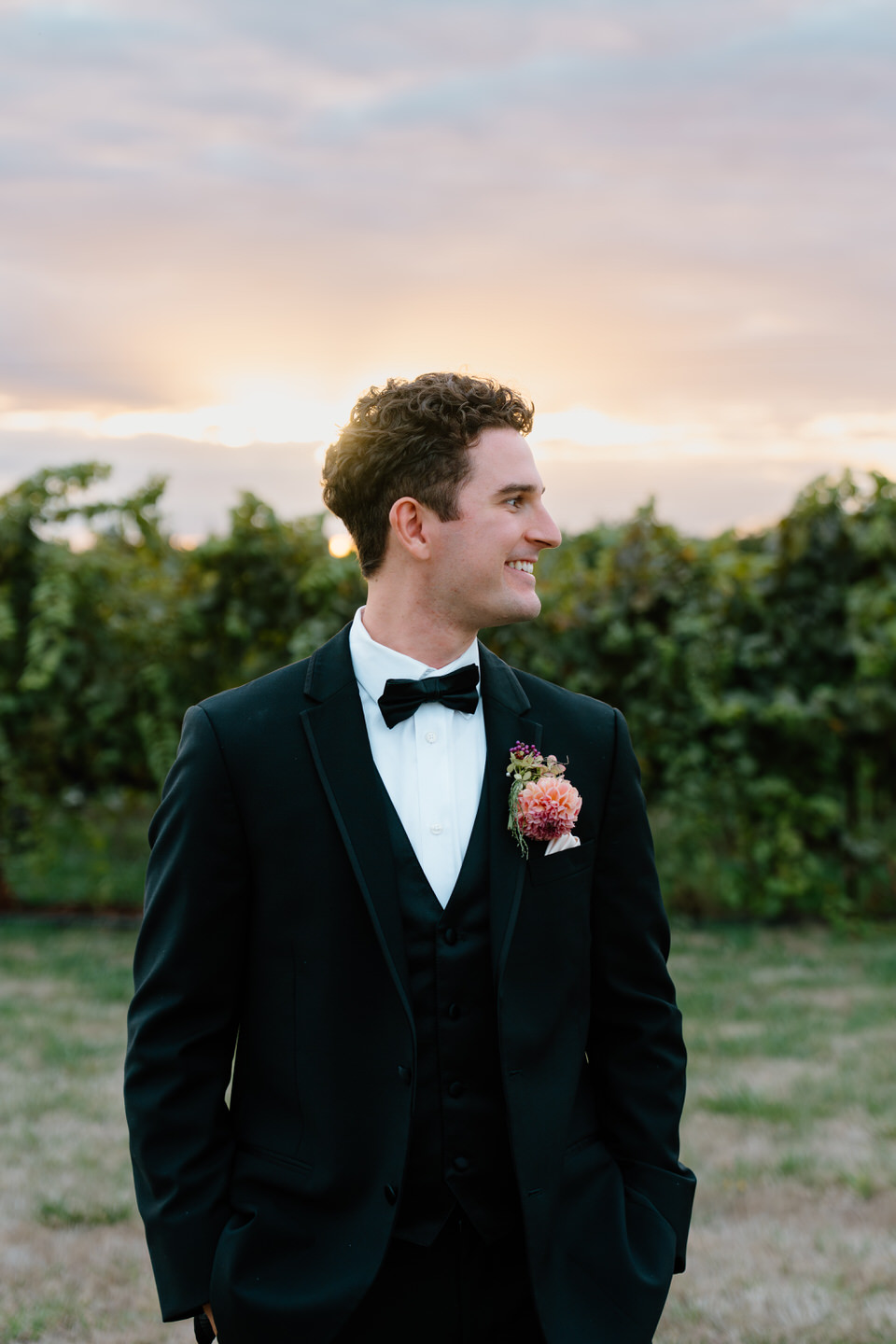 Groom smiles to the side during golden hour portraits.