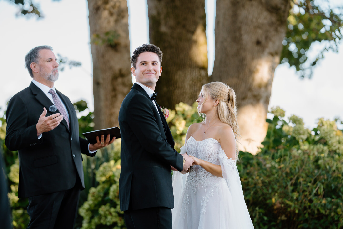 Groom smiles back at his family during wedding ceremony.