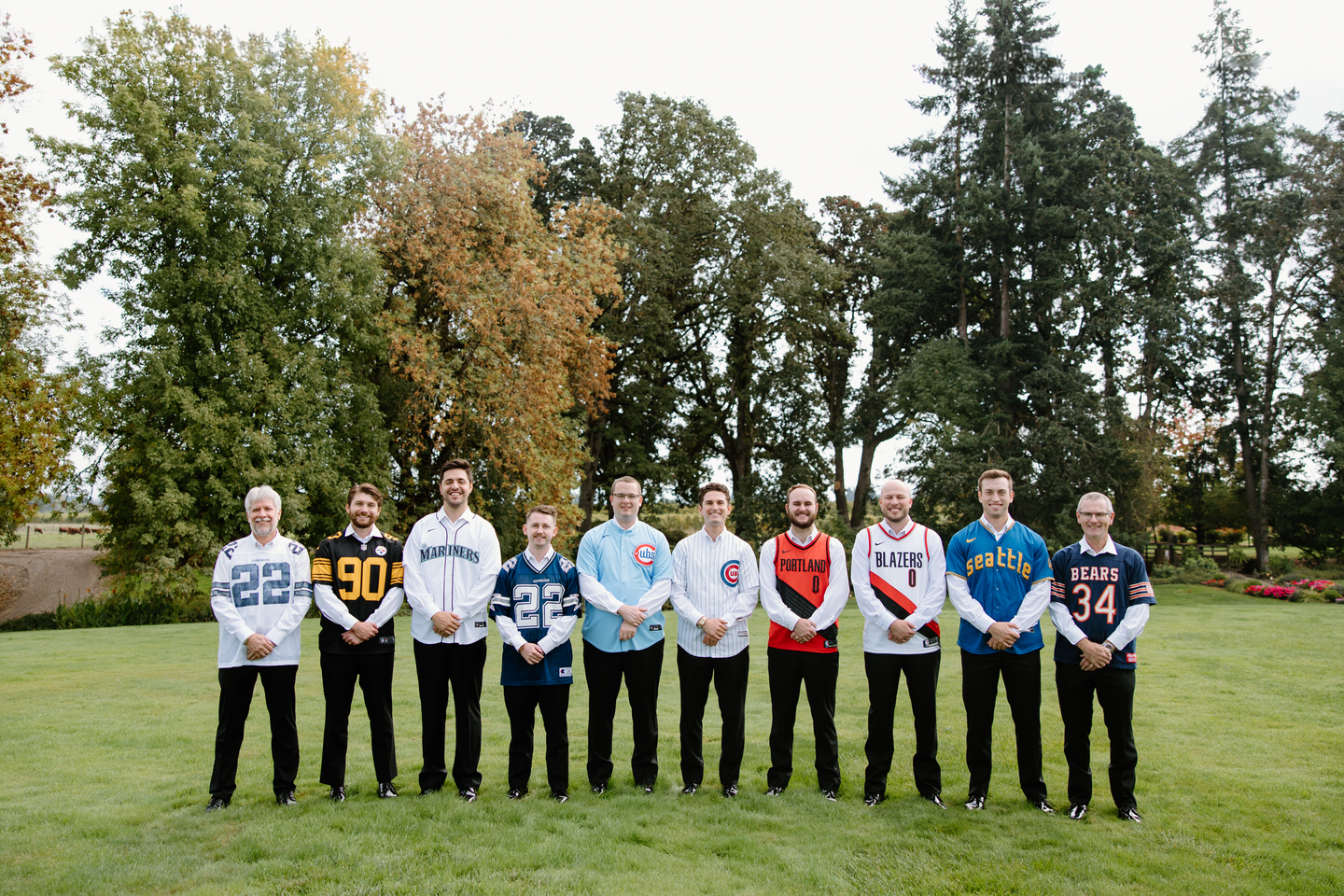 Groomsmen pose in a variety of sports jerseys.