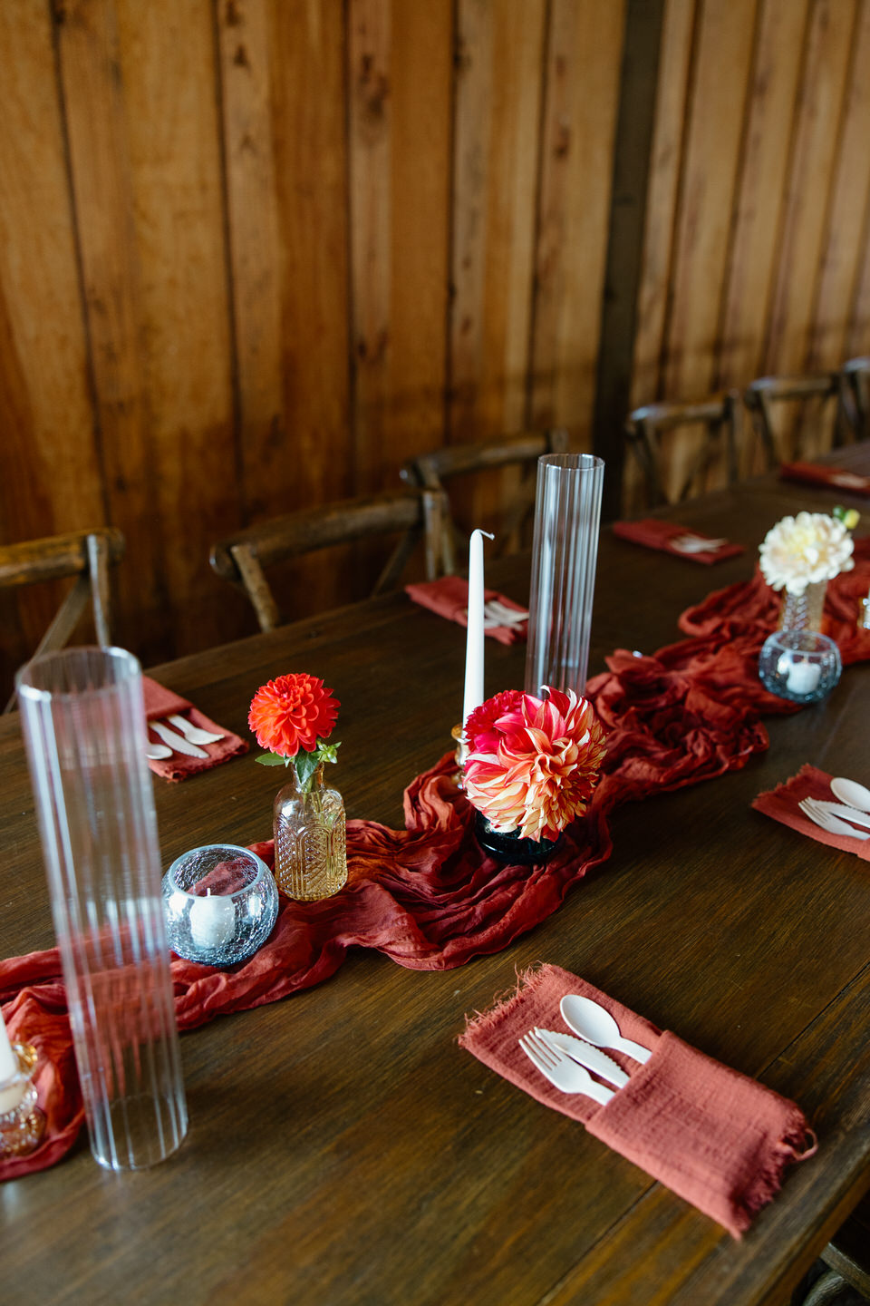 Gold and orange wedding decor on wood tables.