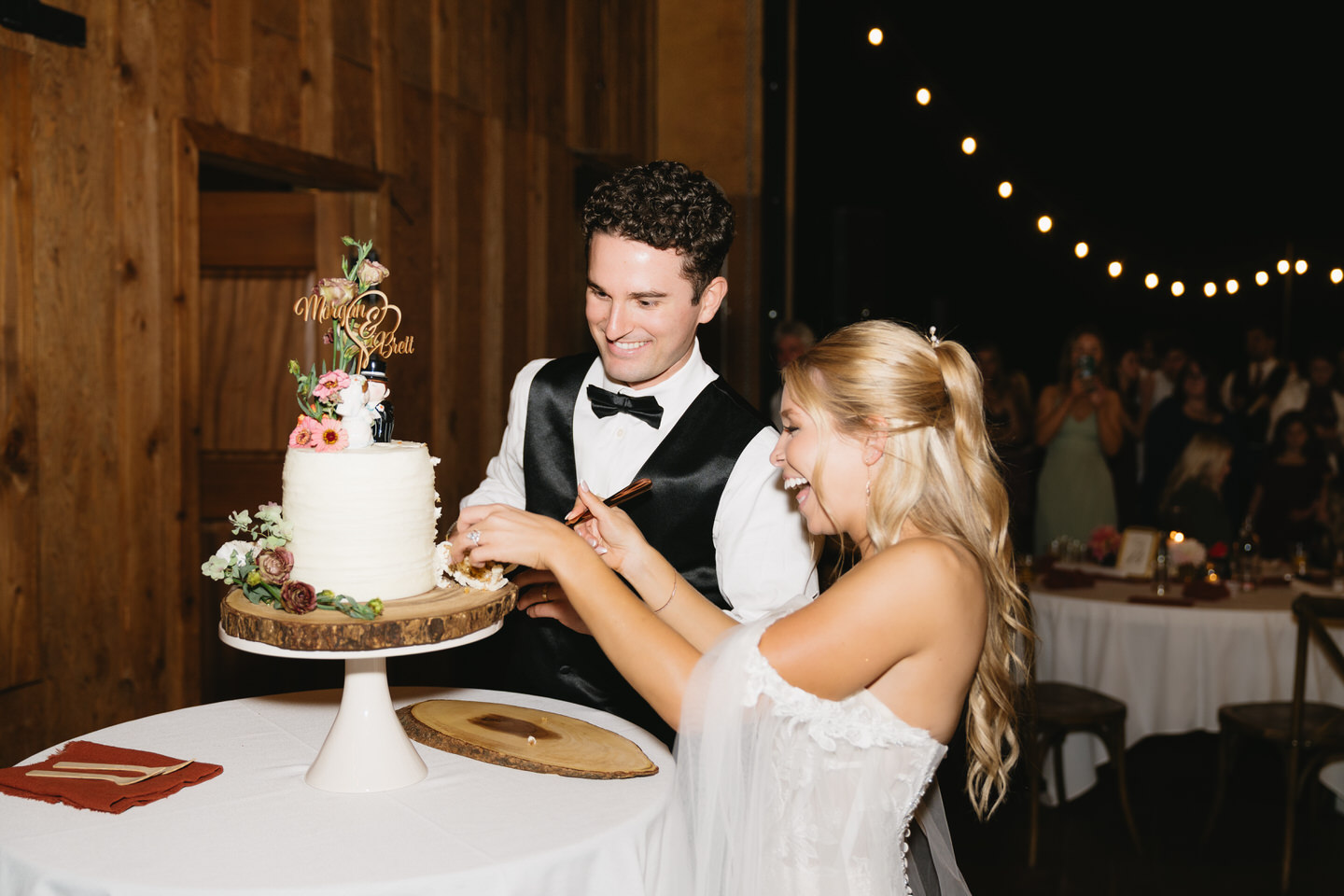Bride and groom cut their cake inside the barn at Postlewaits.