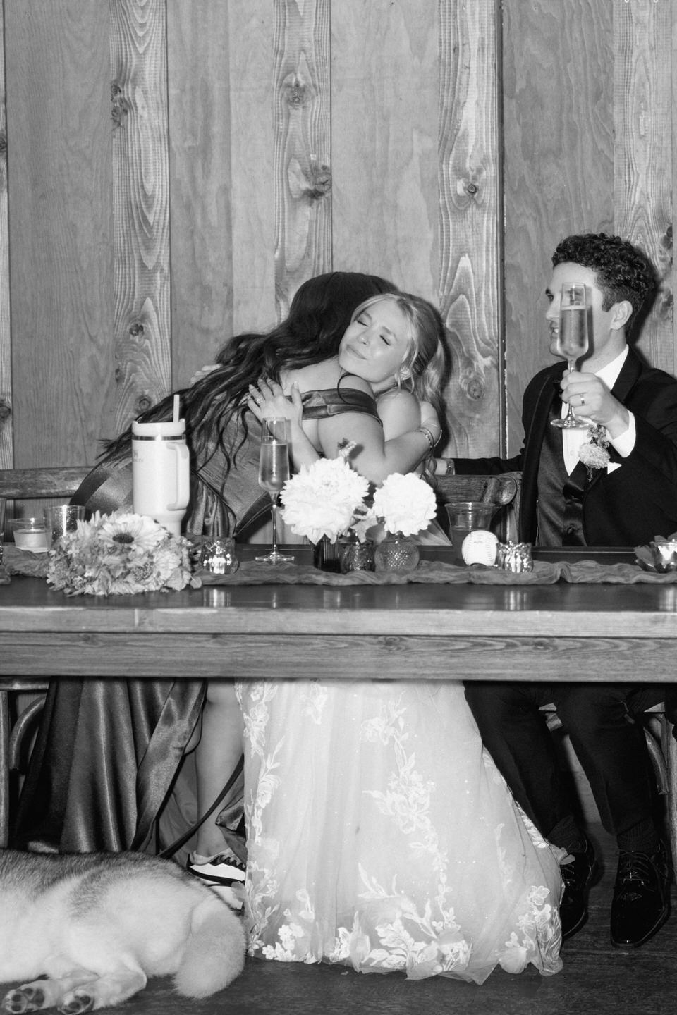 Bride and her sister hug after a speech.