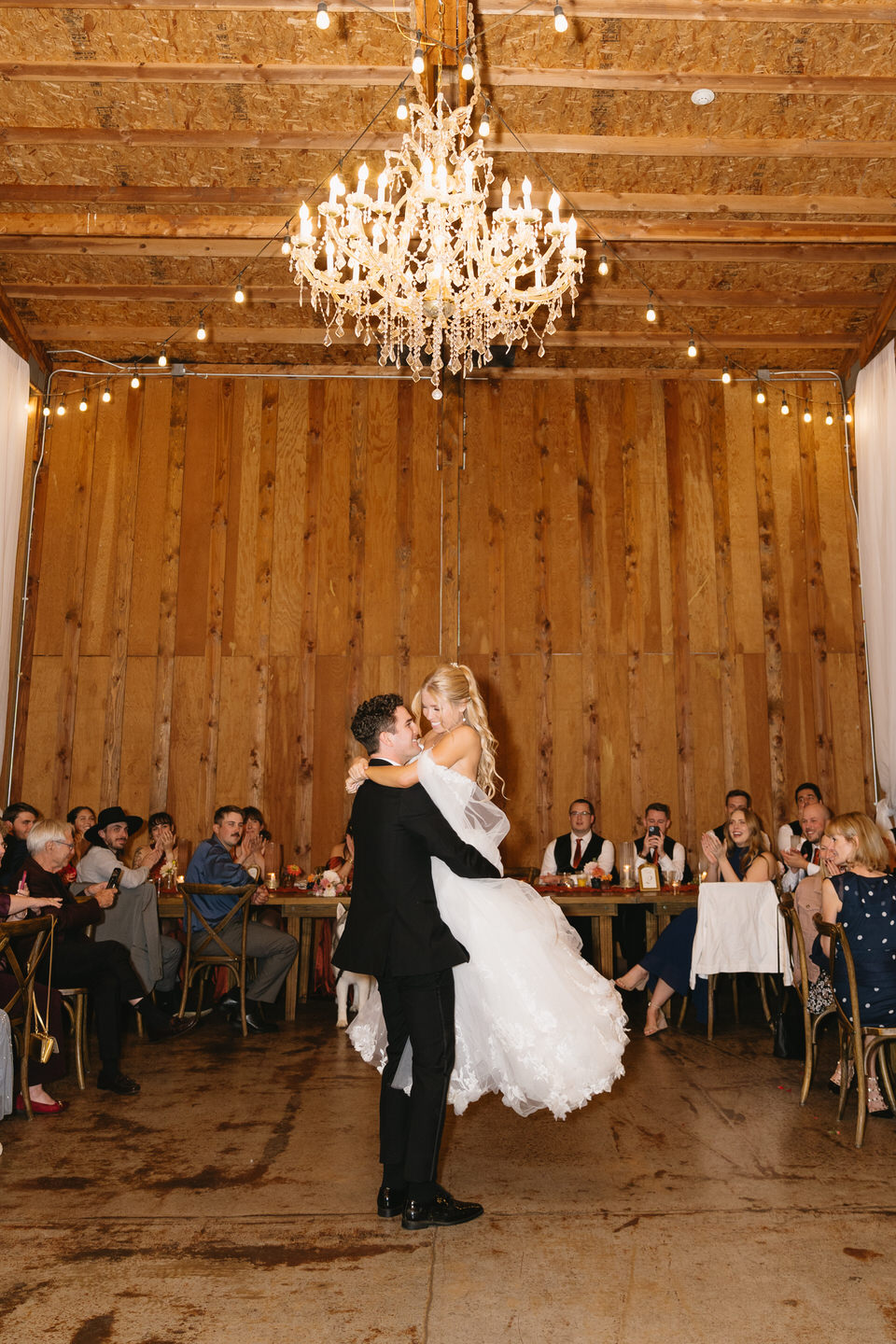 Groom lifts up the bride during their first dance at their Postlewait's wedding.