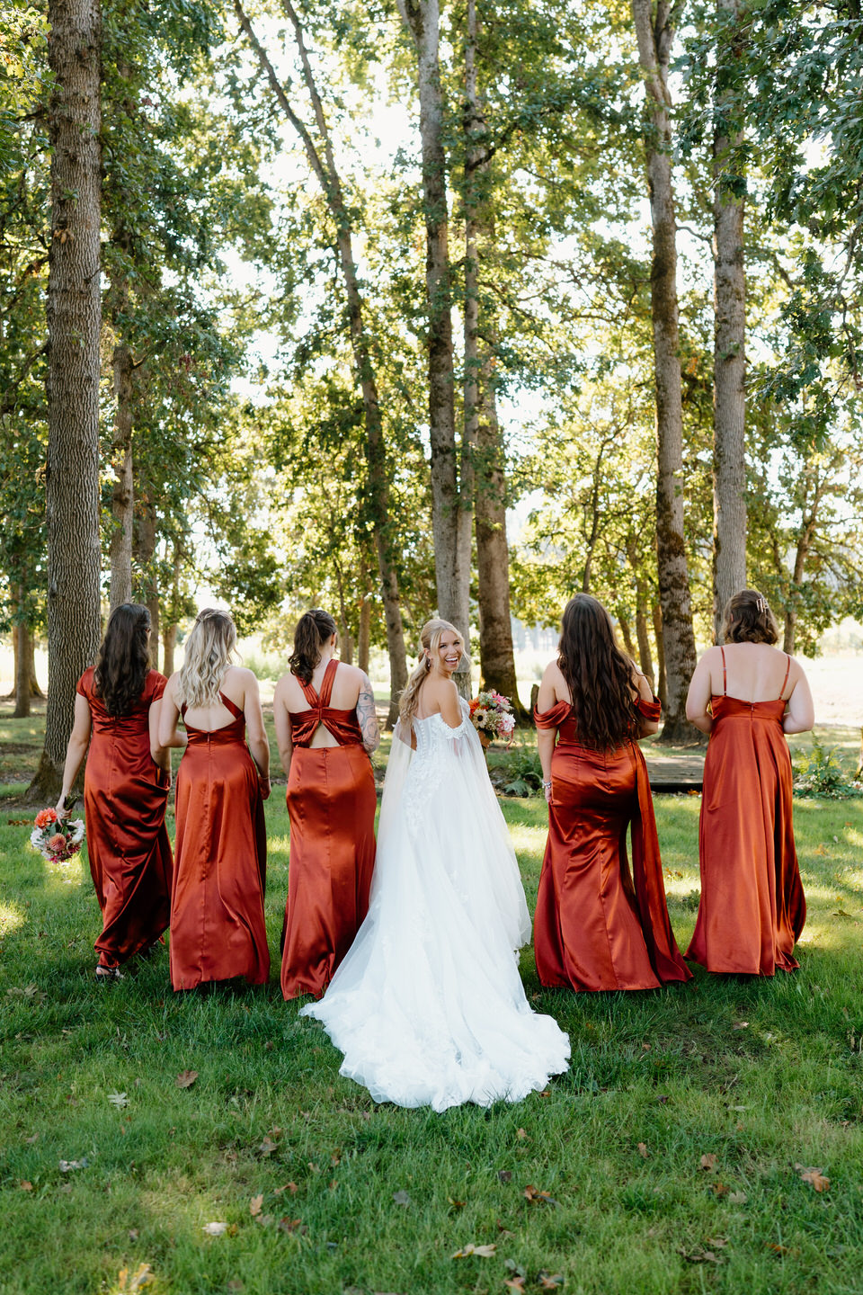 Bridesmaids walk through the oak tree area at Postlewaits.