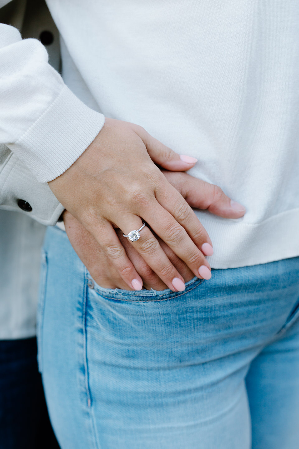 Close up of fiancee's round engagement ring.