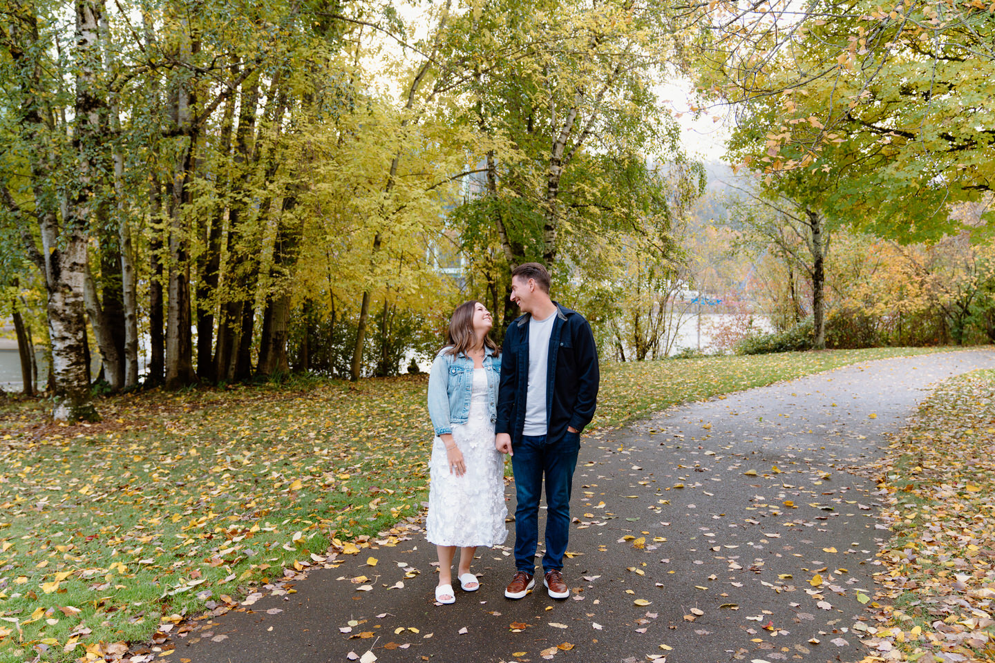 Couple looking at each other among the fall foliage in Oregon at Cathedral Park.