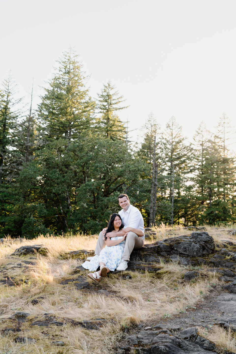 Couple sitting in a meado near Lacamas Lake in Vancouver, WA.