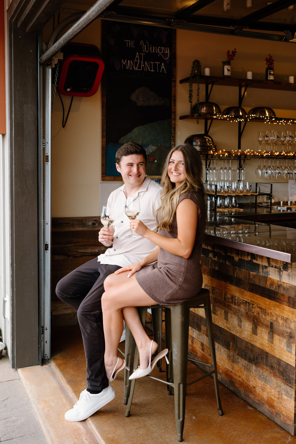 Engaged couple sits at the bar at The Winery at Manzanita.