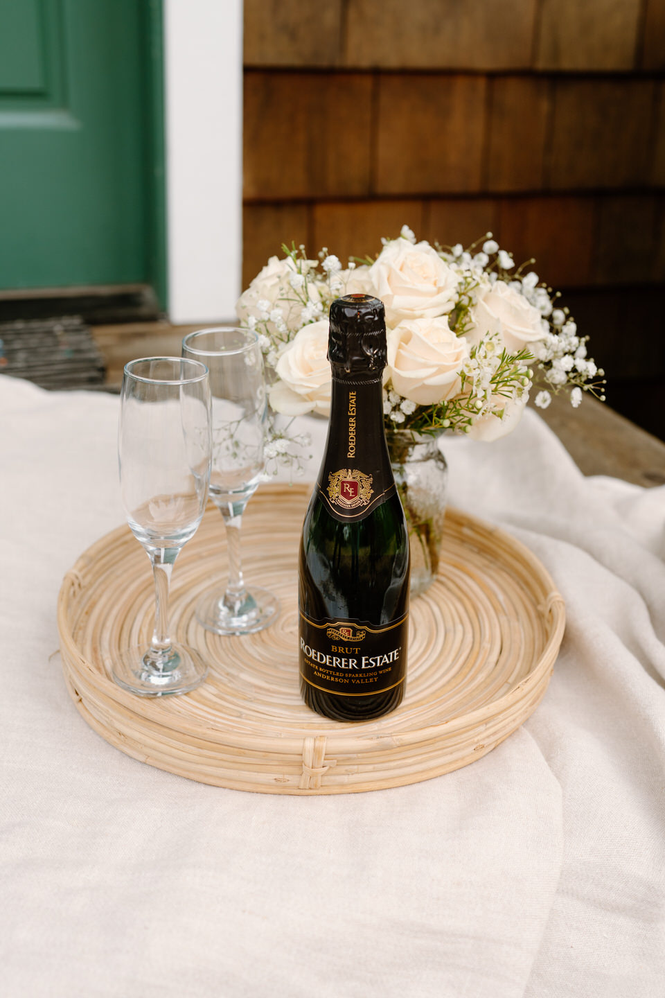 Picnic celebration on the front porch, including champagne and flowers.