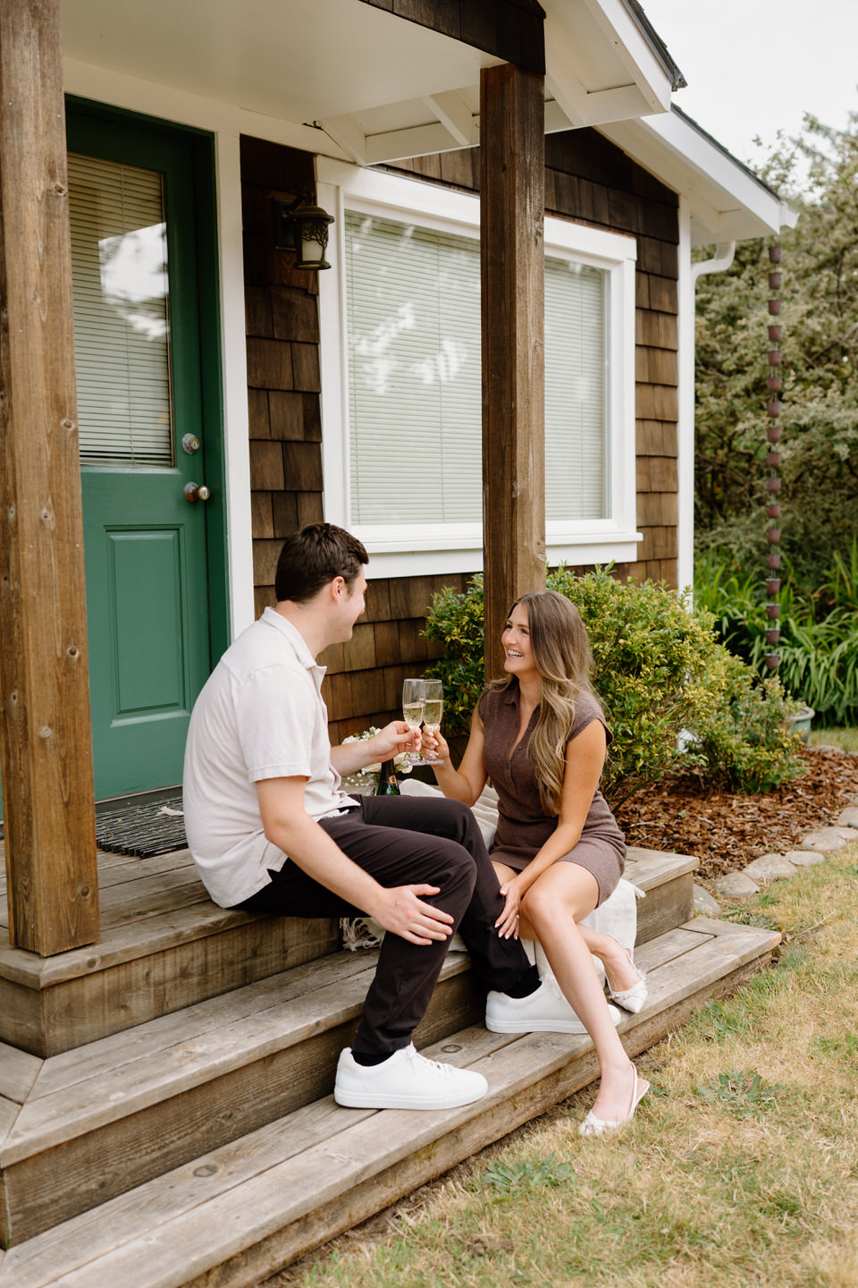 Engaged couple sitting on the front porch in Manzanita.
