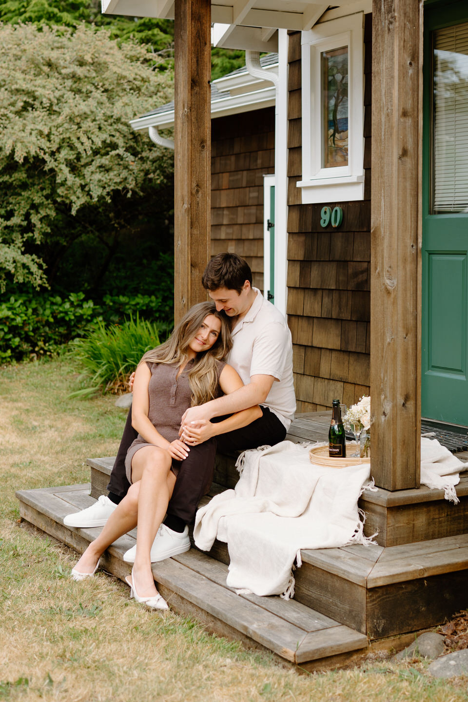 Couple gets close on the front porch of their Manzanita beach house for engagement photos.