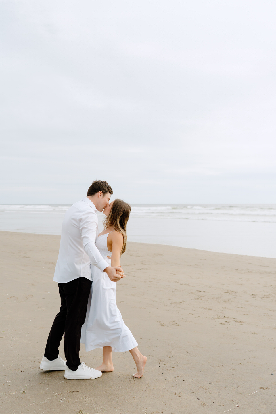 Couple dancing together, carefree on the beach for their Manzanita engagement photos.