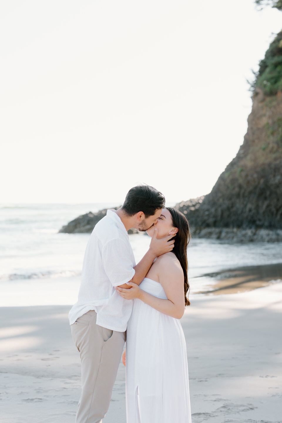 Couple shares a kiss during their engagement photos at the Oregon Coast.