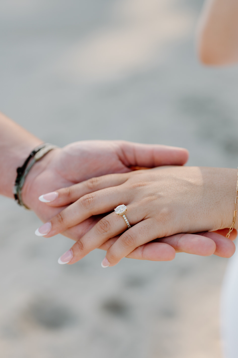 Close up of an oval cut engagement ring with hidden halo detail.