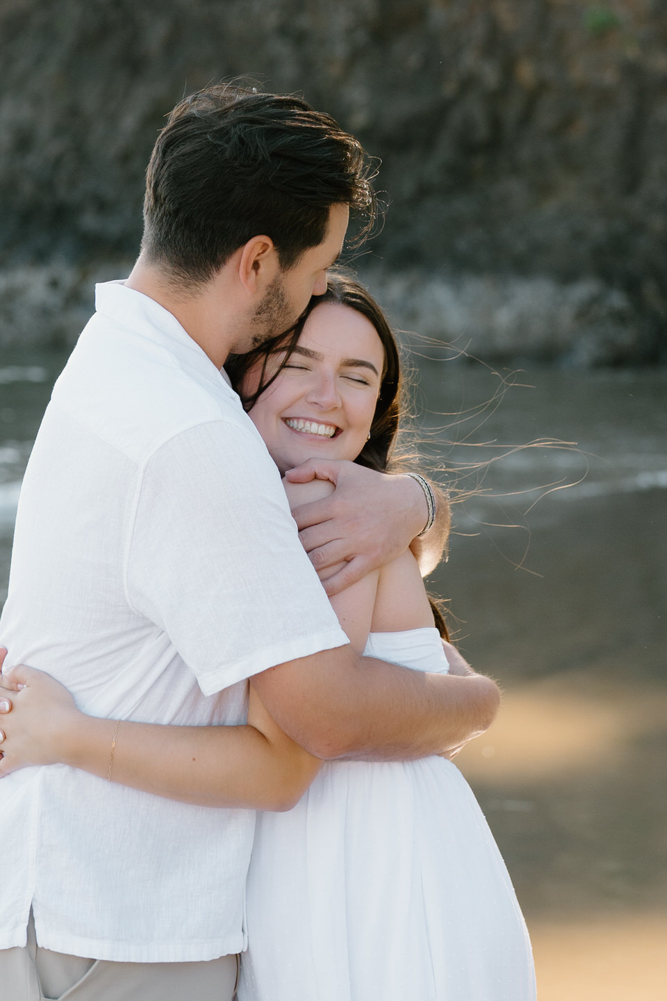 Couple share a hug in the midst of their dreamy engagement photos on the Oregon Coast. 