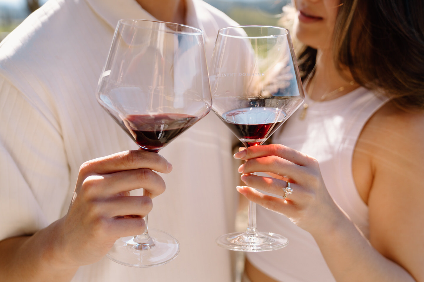 Engaged couple celebrating with wine in the vineyards at Eminent Domaine winery in April.