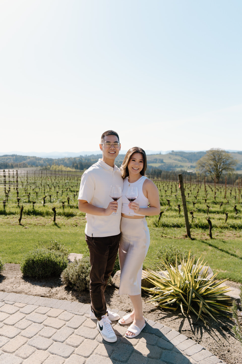 Oregon wine country proposal celebration with couple smiling together at Eminent Domaine winery in spring.