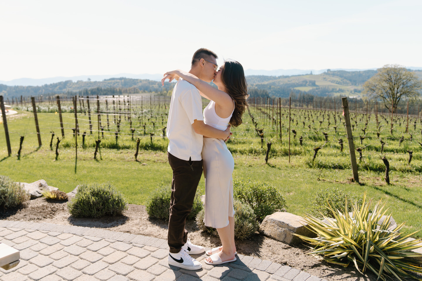Oregon wine country proposal moment captured in the vineyards at Eminent Domaine winery with hills in the distance.