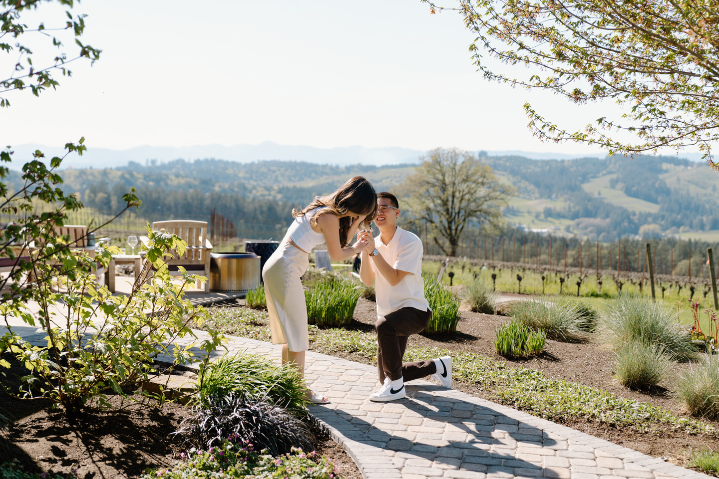 Woman is surprised by wedding proposal in the glowing April light.