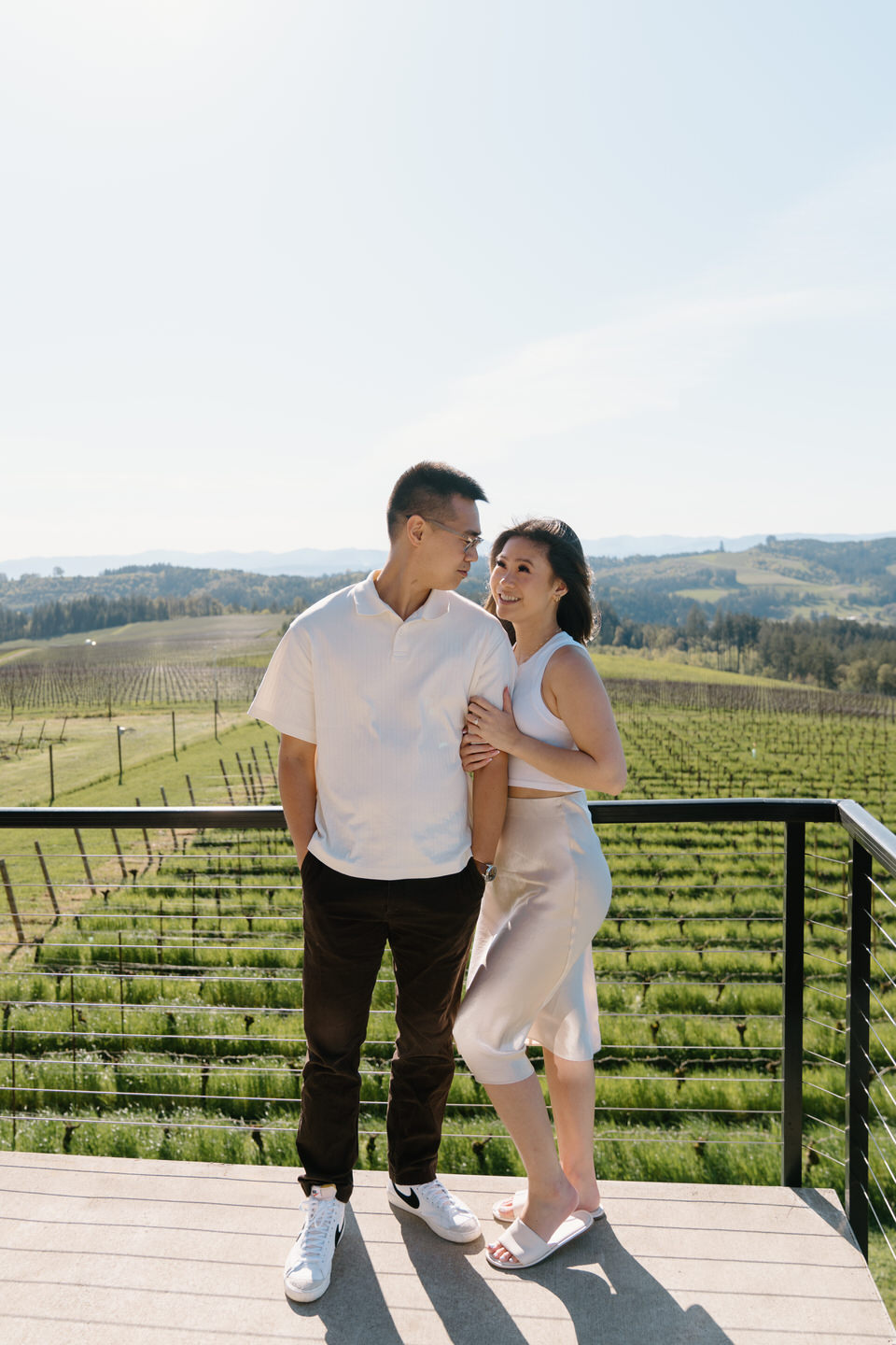 Oregon wine country proposal at Eminent Domaine winery with spring vineyards and soft light framing the engaged couple.
